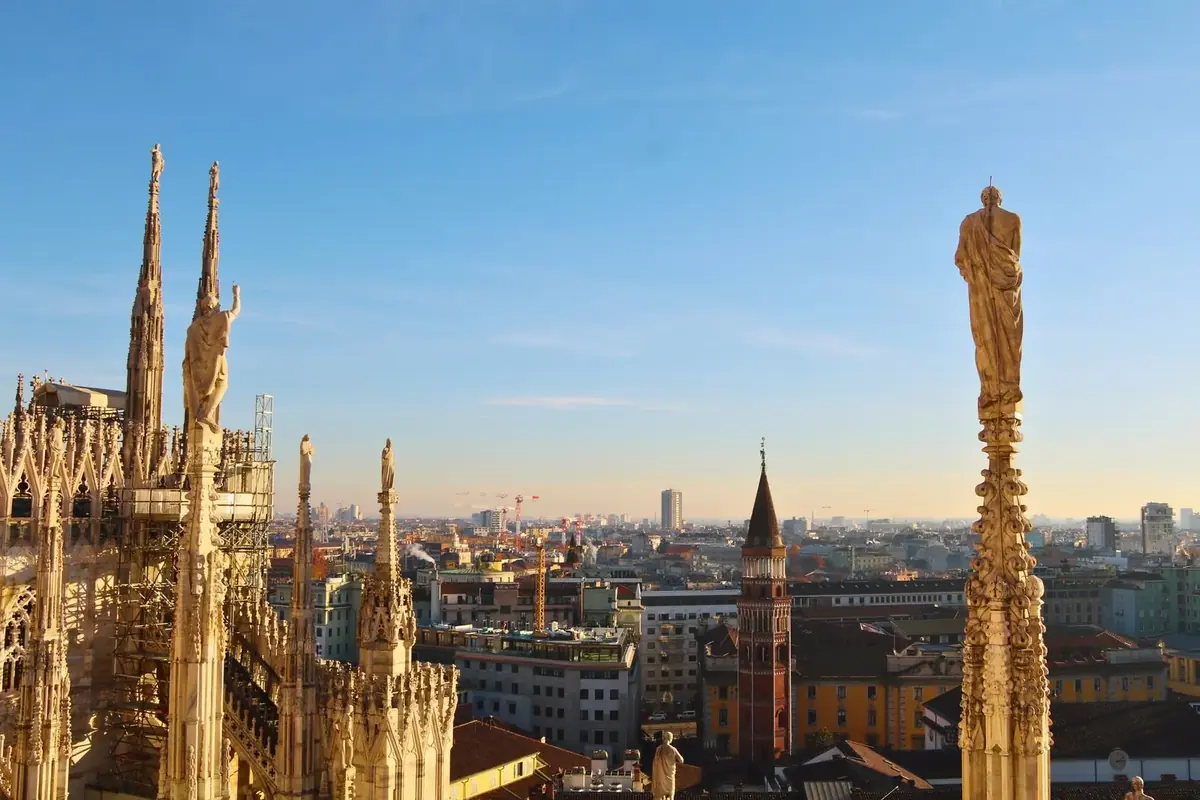 Spires and statues on the Duomo rooftop at sunset